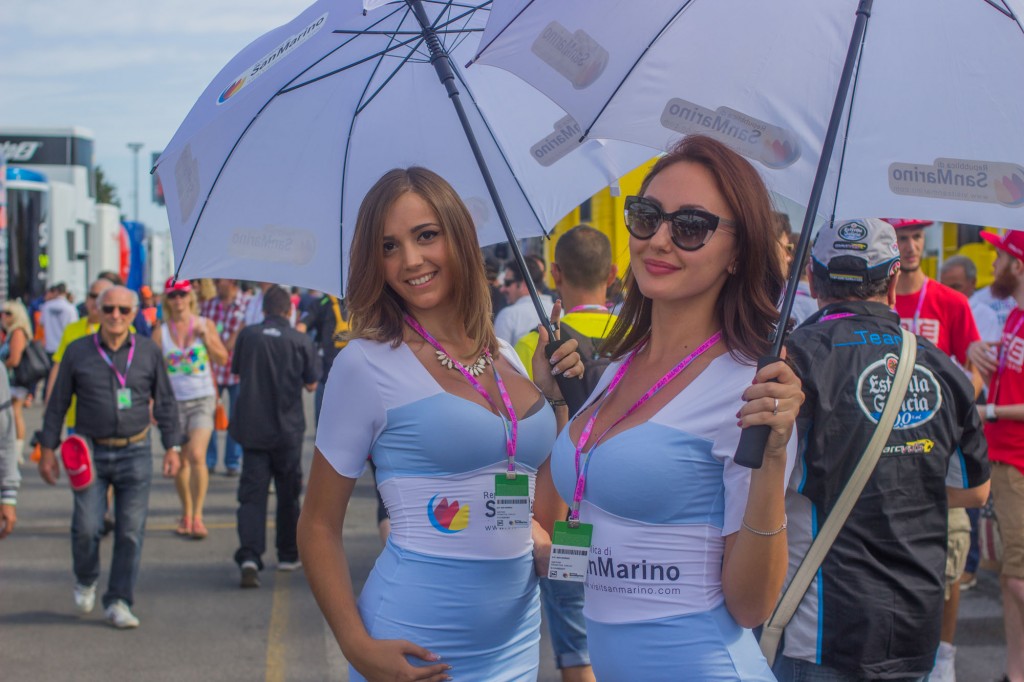 Do you know how much it costs to name a MotoGP after you? For the "Gran Premio di San Marino e della Riviera di Rimini", exactly 1,069,387.20 Euros are paid to the organizers. San Marino, which shares the cost with some of the cities of the Adriatic coast, is a small independent country that distances about 40 kilometers from the circuit. Not a lot of tourists reach it during the race week end, so San Marino tries to maximise the image-impact of its presence in several ways. One is the quality of the umbrella girls. The beauties were constantly busy taking photos with the paddock visitors. 