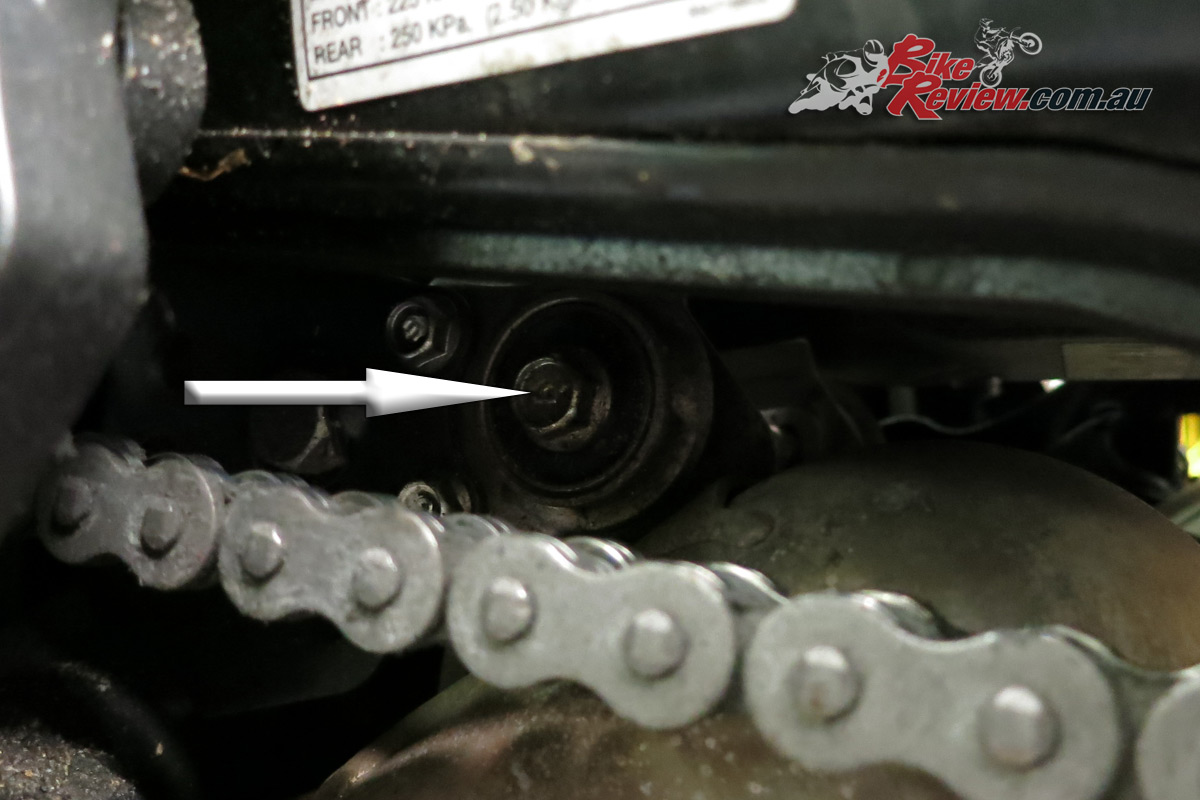 On the other side you're undoing the bolt through the rubber exhaust mount. You'll need to reach it past the chain.