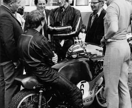 Timman seated on bike after winning Dutch 500cc title talking with runner-up Frank Coopman.