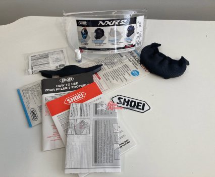 The kit includes a Pinlock, breath guard, chin spoiler, stickers, lubricant, a bag and manuals.