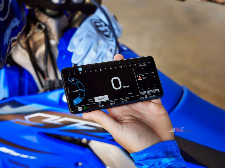 An enhanced real-time monitoring screen displays motorcycle speed, throttle position, engine rpm, fuel consumption, coolant temperature, intake air temperature, battery voltage, smartphone battery level and the current time. 